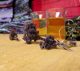 Obraz na płótnie Canvas Herbal tea with oregano in glass glasses. A bouquet of dried oregano.