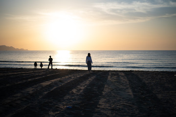 沈む夕日と水平線と浜辺と人