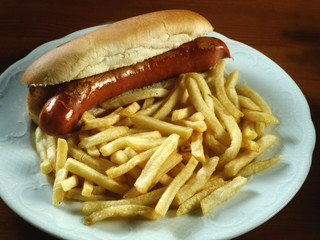Plato con un bocadillo de Frankfurt y patatas fritas