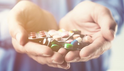 Hands with colorful pills and tablets