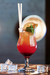 Lighting equipment on background. Cocktail is ready. On the wooden table in the night club