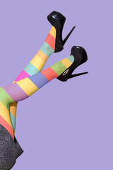 Female long legs wearing black high heels and multicolor tights
