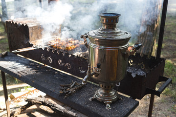 Fototapeta na wymiar Barbecue with a samovar and grilled meat in nature