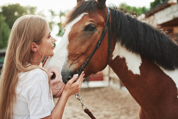 On weekend. Happy woman with her horse on the ranch at daytime