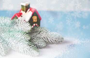 House miniature and Christmas tree branch on the blue background. Winter Christmas concept