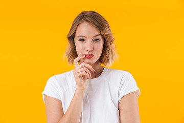 Image of alluring blond woman in basic t-shirt looking at camera