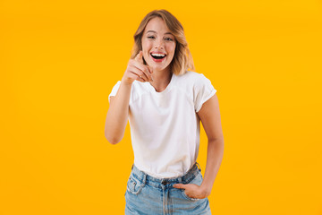Image of surprised blond woman smiling and pointing finger at camera