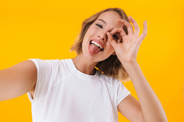Image of caucasian blond woman showing ok sign and taking selfie photo