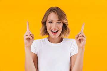 Image of beautiful blond woman smiling and pointing fingers upward