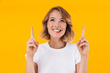 Image of joyful blond woman smiling and pointing fingers upward