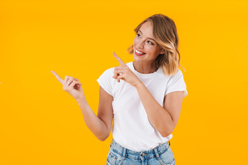Image of pleased blond woman smiling and pointing fingers aside