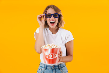 Obraz premium Image of woman in 3D glasses holding popcorn bucket while watching movie