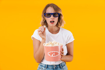 Image of woman in 3D glasses holding popcorn bucket while watching movie