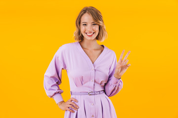 Image of woman in elegant dress smiling and showing peace sign