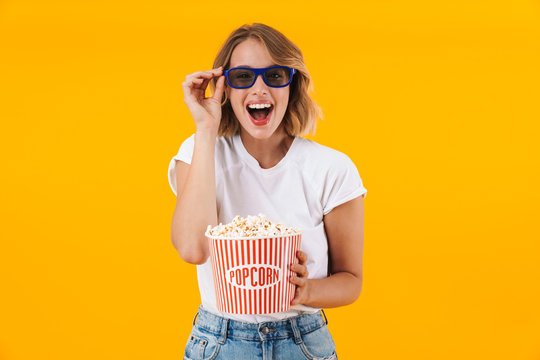 Image of woman in 3D glasses holding popcorn bucket while watching movie