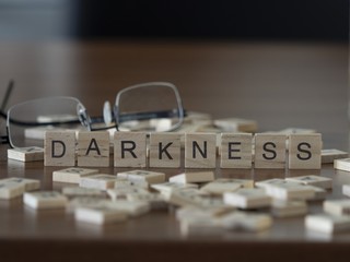 The concept of Darkness represented by wooden letter tiles