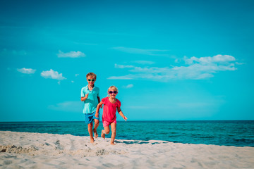 little boy and girl running on beach