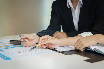 Business woman and partner hand pointing at finance chart for planning about marketing, tax, accounting, statistics and analytic research concept.