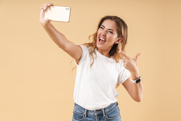 Portrait of alluring woman smiling while taking selfie photo on cellphone