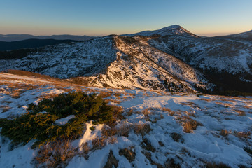 Beautiful winter landscapes from the Ukrainian Carpathian Mountains with traumatic skies and tourists, traveling on ridges