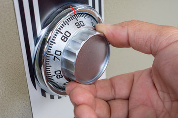 Close-up of hand searching security code of safe.