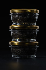Glass jars with black sturgeon caviar.