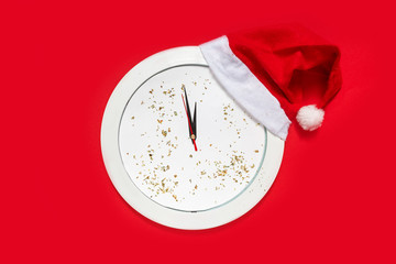 New Year Christmas Top view flat lay white clock with santa hat and rat 2020 symbol and glitter on pink festive background, gold stars confetti copy space millennial red color paper background