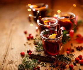 Christmas mulled red wine with spices and citrus fruits on a wooden rustic table, copy space....