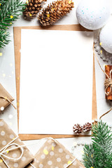 Merry Christmas and happy New year. Mockup with postcard and branches of a Christmas tree on white background.Background with copy space. Selective focus. Top view. Christmas background.