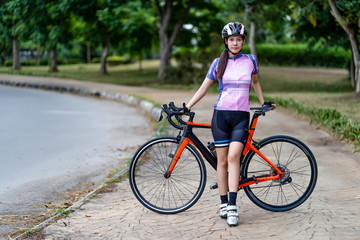 Road bicycle woman riding her bike and action cyclist trains for fitness and health care.