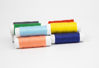 The threads of different colorful with the coils on a white background.