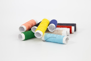 The threads of different colorful with the coils on a white background.