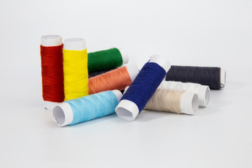 The threads of different colorful with the coils on a white background.