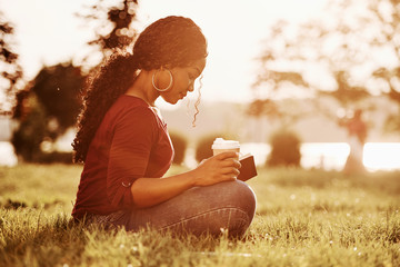 Almost sunset. Cheerful african american woman in the park at summertime