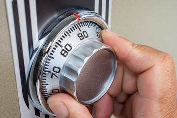 Close-up of hand searching security code of safe.
