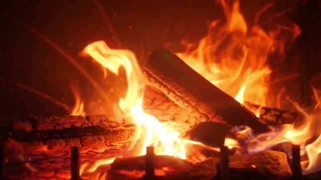 Closeup slow motion video of beautiful fire flames and burning wood in the fireplace at house