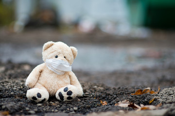teddy bear sits on dirty ground
