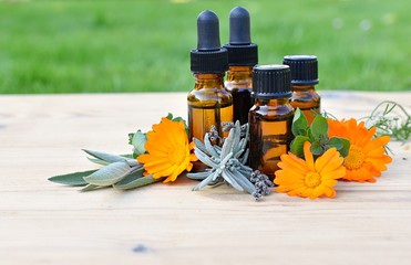 Set of brown bottles with essential and cosmetic oils, fresh herbs and flowers, aromatherapy,...