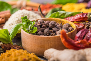 Heaps of various ground spices in wooden spoons on wooden background. Georgian spices, Indian spices, Arabian spices. Spice variety. Herbs and spices