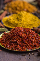 Heaps of various ground spices in little plate on wooden background. Georgian spices, Indian spices, Arabian spices. Spice variety. Herbs and spices