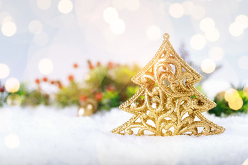 Christmas gold tree decoration on real snow outdoors. Winter holidays concept.