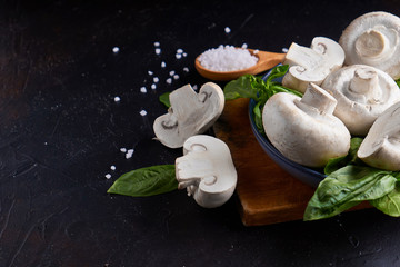 portobello white mushrooms Large champignon with basil in plate on dark stone background Close-up