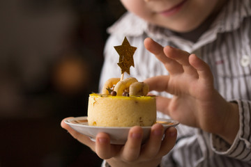 New Year and Christmas  cake or cheesecake on black background. festive mini cheesecake, with little boy hand