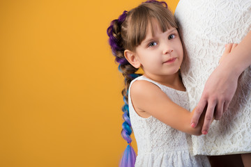 Girl slyly listens to mother's pregnant belly