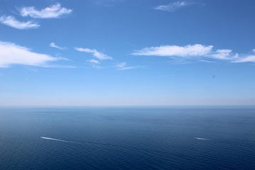 Fototapeta na wymiar Orizzonte marino con cielo nubi e imbarcazioni