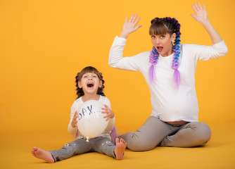 Funny pregnant mother and little daughter