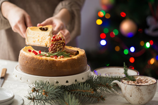 New Year and Christmas Glowing colorful lights on black background. festive cheesecake, with woman hand