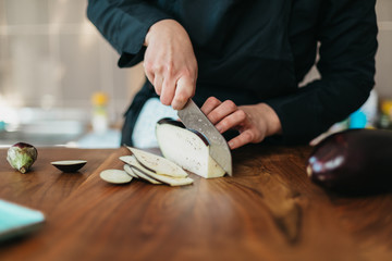Female chef preparing meal with eggplant
