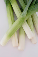 Close up of a bunch of fresh green leeks in a white background