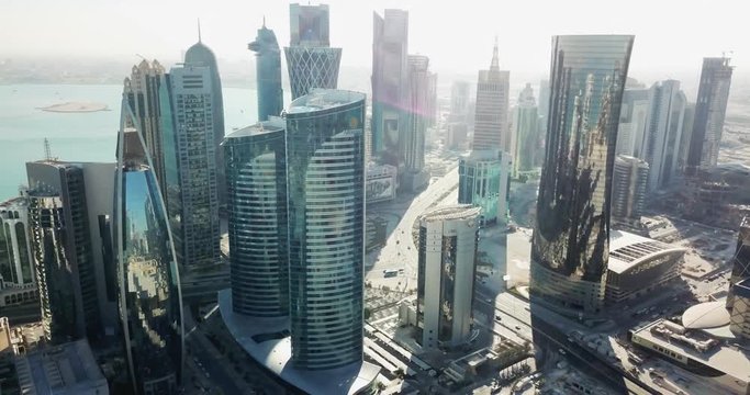 Aerial forward flying view of a futuristic global city with high buildings and towers, developped capital with big avenues, Doha West Bay, Qatar